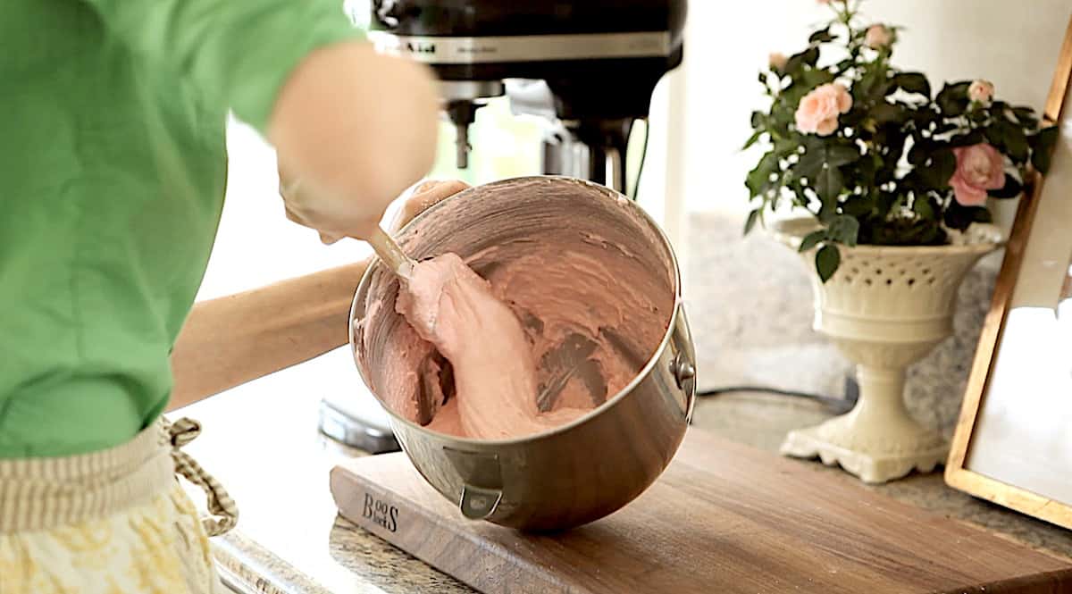 a person folding dry ingredients into macaron batter