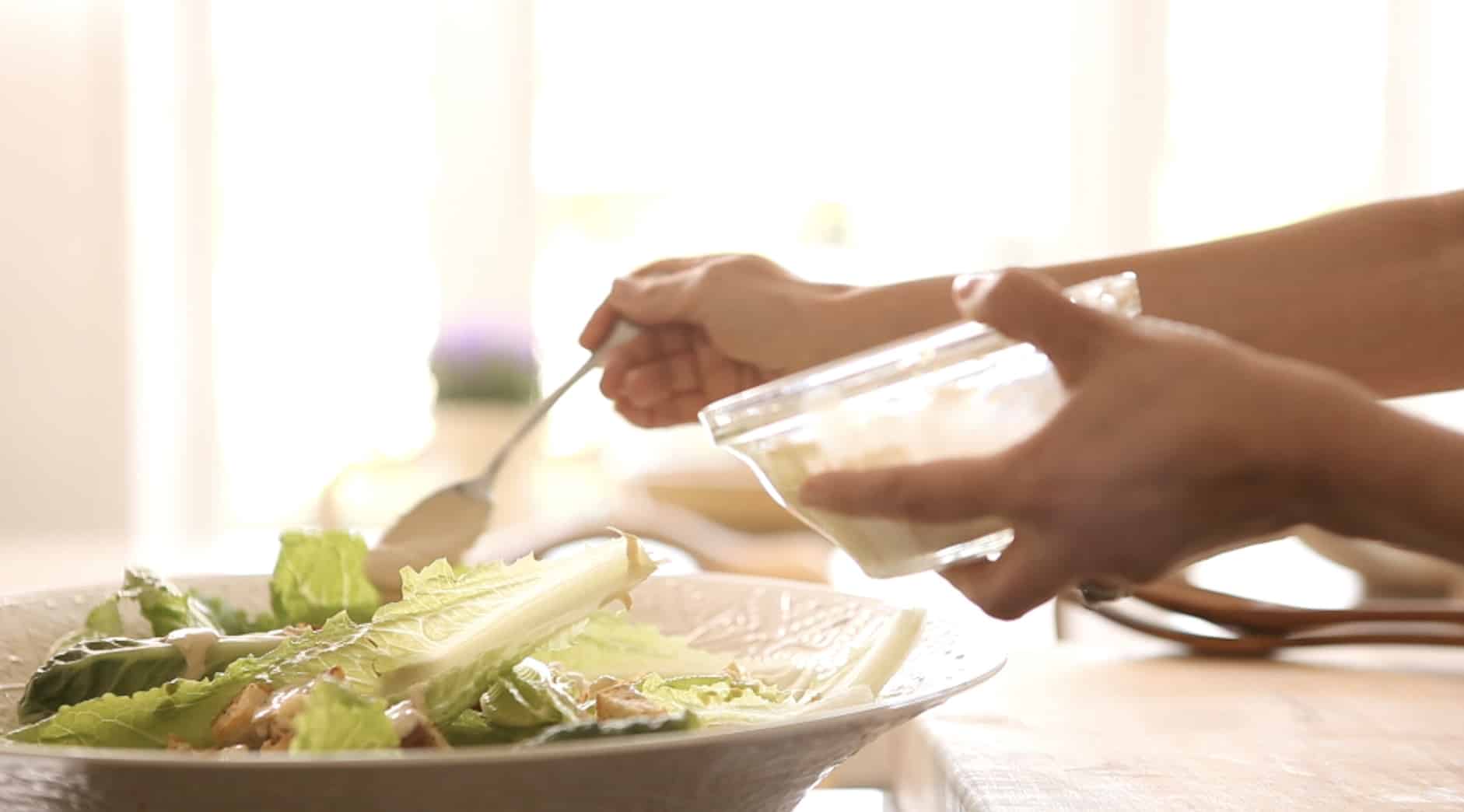 Grilled Chicken Caesar Salad getting a touch of homemade caesar dressing