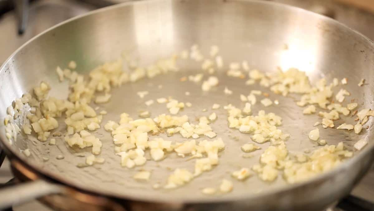 shallots sautéing in a pan with oil