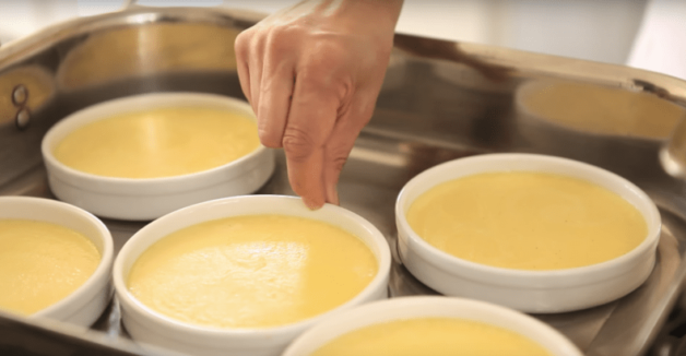 Placing creme brulee ramekins in a roasting pan