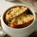 French Onion Soup in a White Bowl with bubbly cheese and toasted bread