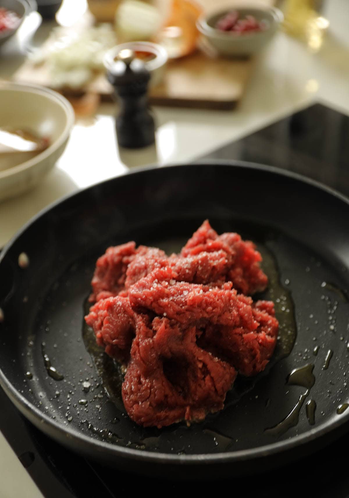Ground Beef in a pan cooking in oil.