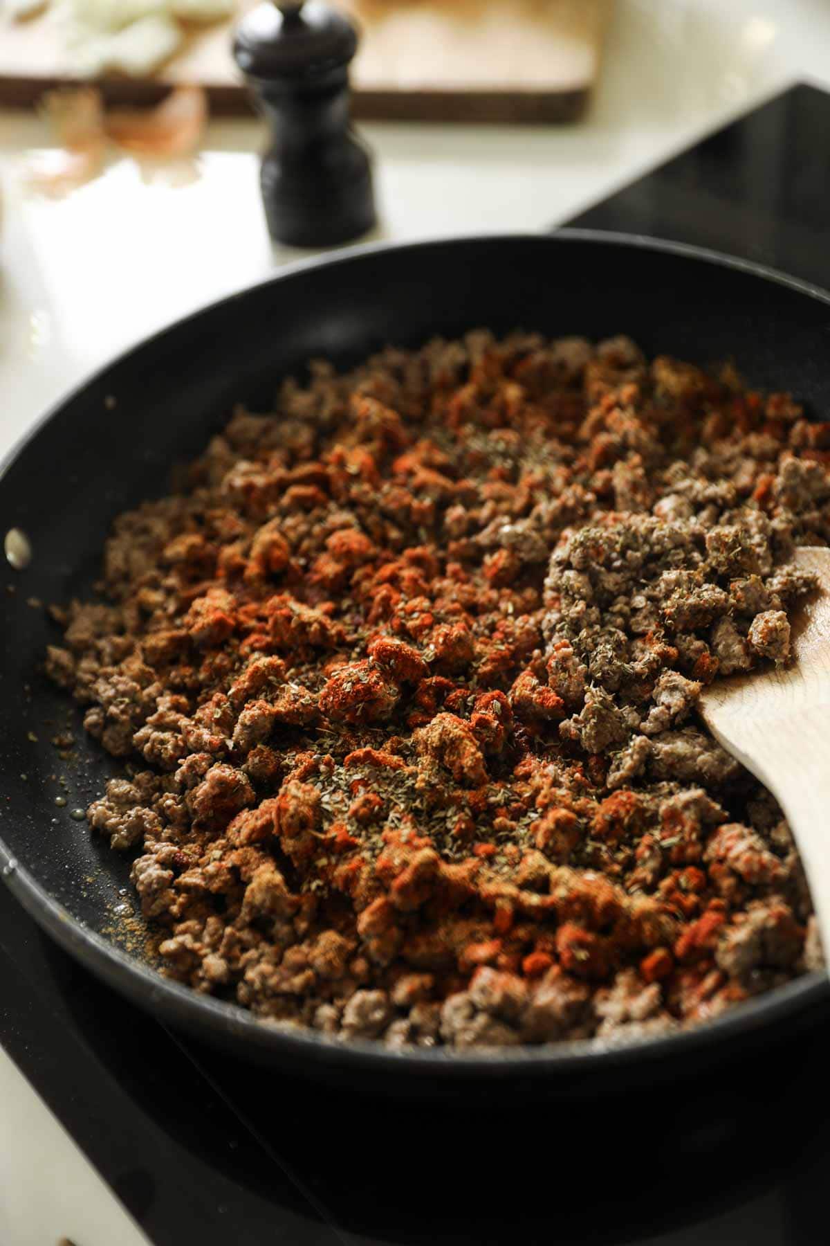 cooked ground beef in a large skillet with spices.