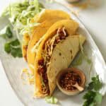 Slow Cooker Taco on a Plate with lettuce and cheese.