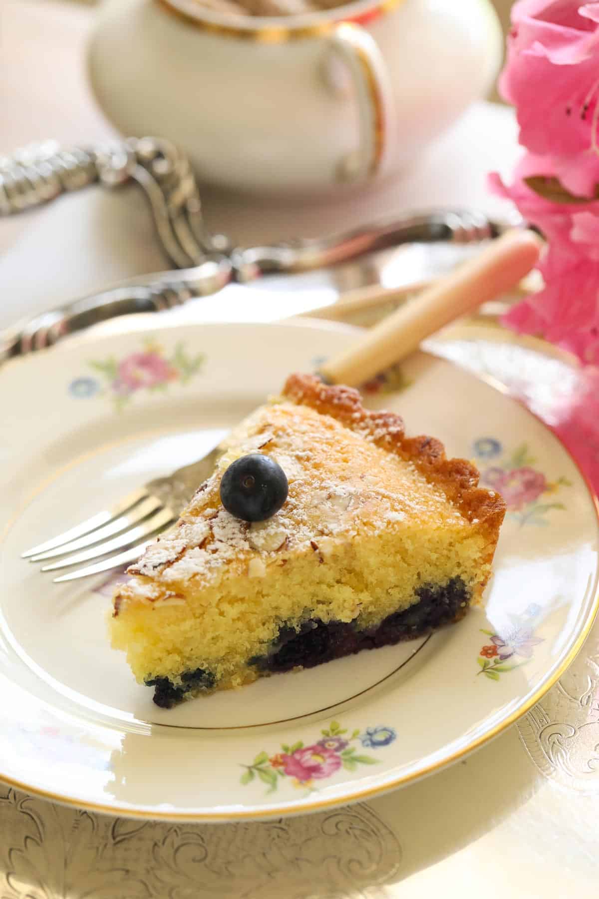 a slice of almond cake with a blueberry bottom