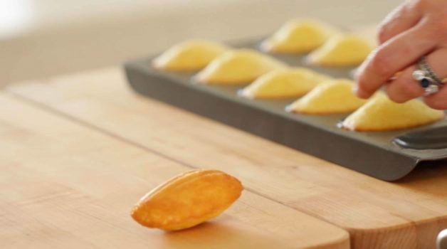 Madeleine cookie being removed from madeleine cookie pan 