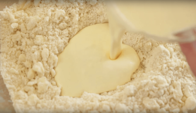 wet ingredients being poured into dry ingredients