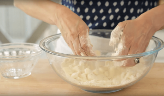 two hands rubbing the shortcake mixture together 