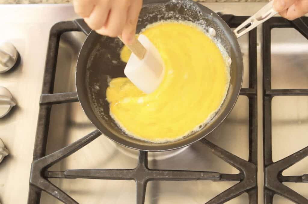 swirling egg and pushing it with a spatula in a small skileet