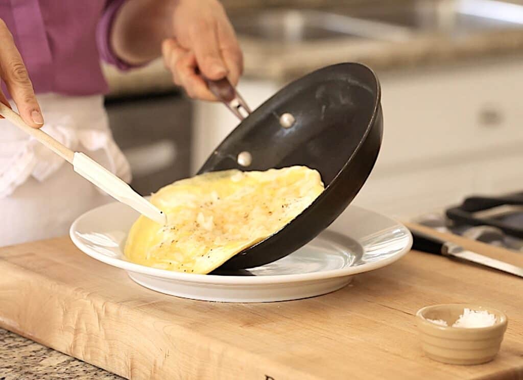 Sliding an omelette out of a skillet on top plate 