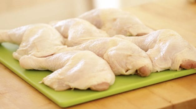 Raw Chicken Legs on a green cutting board