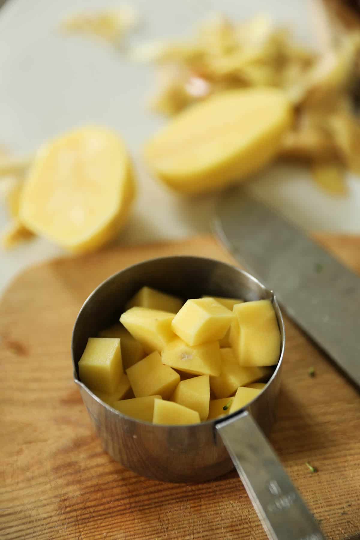 Potato Chunks diced and measured in a measuring cup.