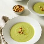 Soup served across three bowls with croutons.