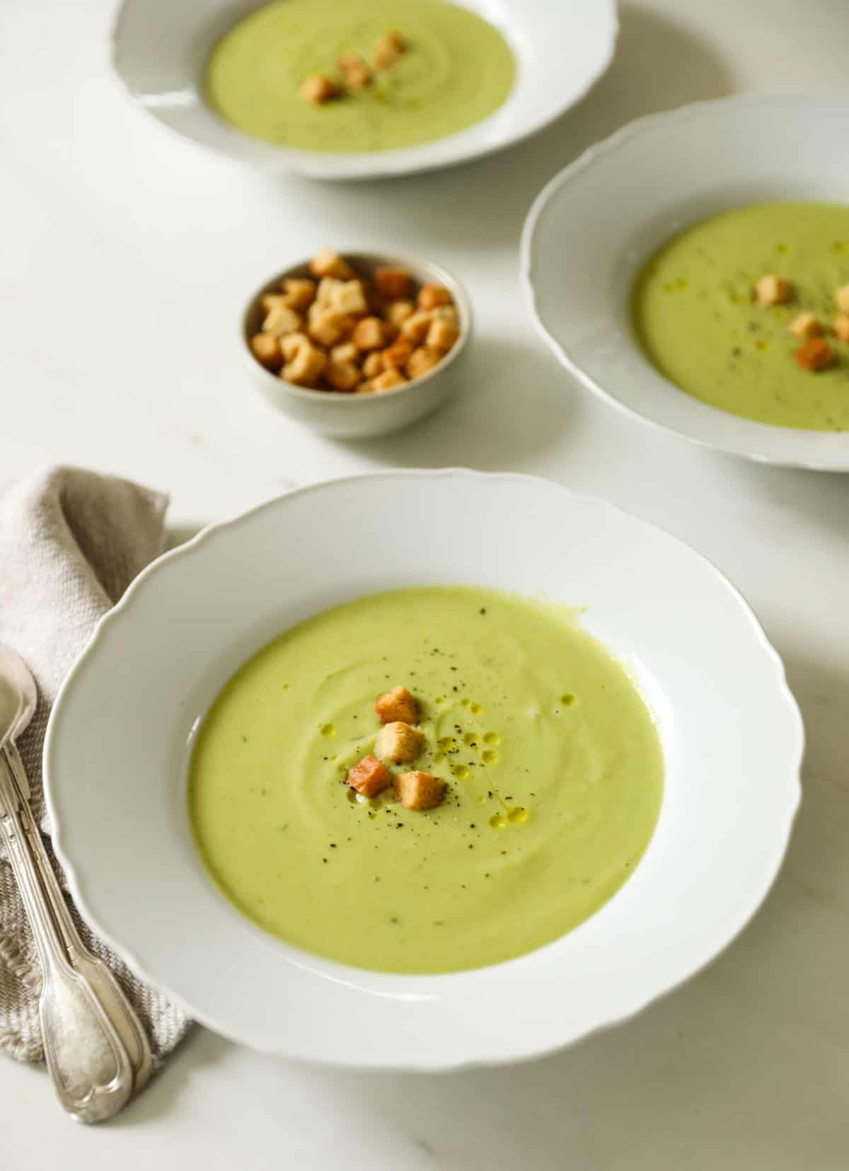 Soup served across three bowls with croutons.
