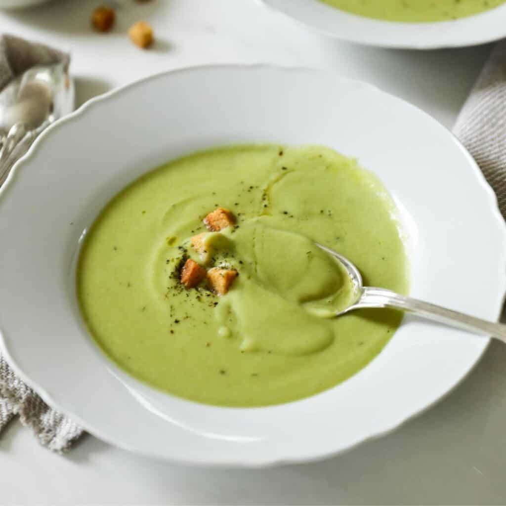 Broccoli Soup with croutons and a silver spoon