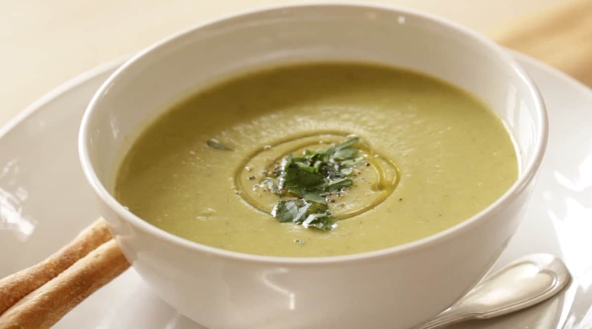 Vegan Cream of Broccoli Soup in a white bowl with Breadsticks