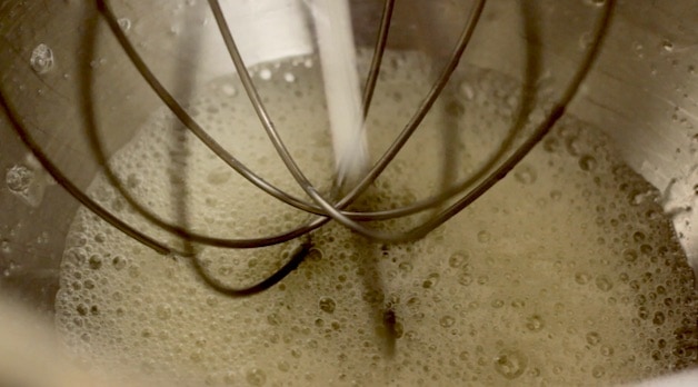 Foamy egg whites in the bottom of a stand mixer bowl