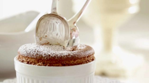 Splitting apart a chocolate souffle with 2 silver spoons