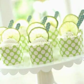 key lime cups served in green cupcake liners on a white cake plate