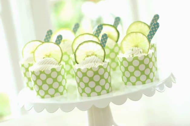 key lime cups served in green cupcake liners on a white cake plate