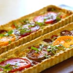 Tomato Tart Recipe baked and served on a dark wood surface