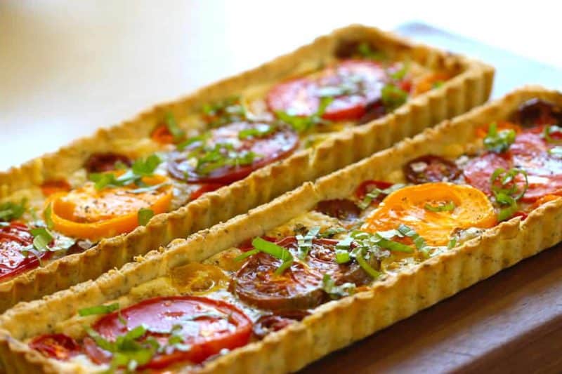 Tomato Tart Recipe baked and served on a dark wood surface