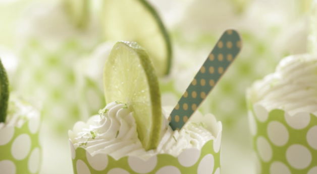 key lime cups served in a green cupcake liner with a wood blue spoon in