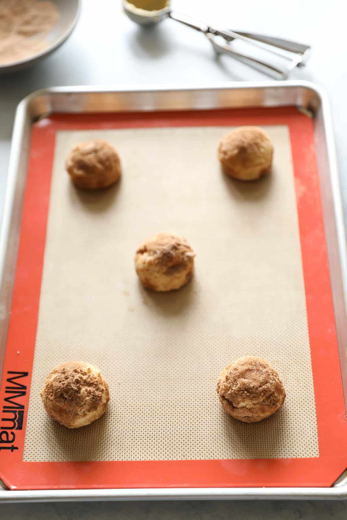 5 dough balls on a baking sheet