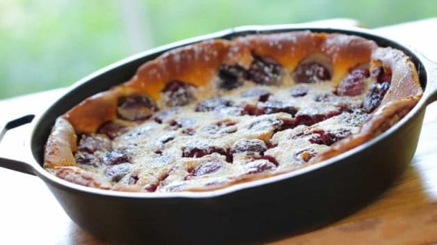 Cherry Clafoutis Recipe baked and cooling in a cast iron skillet