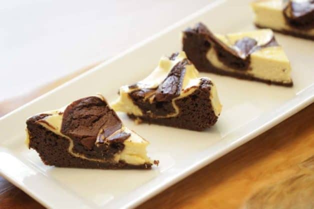 Cream Cheese Brownies sliced into triangles served on a white rectangular platter