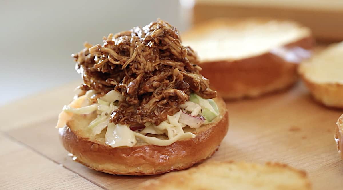 assembling a BBQ Chicken slider onto a brioche bun