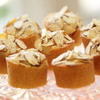 close up of Raspberry Almond Mini Cakes on a pink glass cake stand