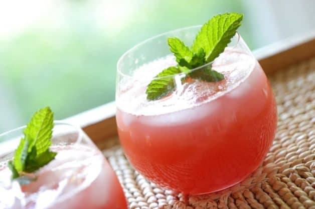 How to Make Watermelon Lemonade recipe served in a small glass with a fresh mint on top 