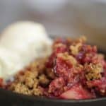 Easy Plum Crumble baked in a cast iron skillet served with a scoop of ice cream
