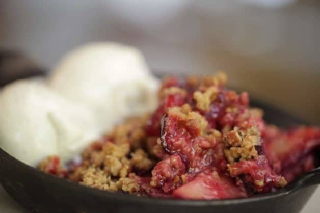 Easy Plum Crumble baked in a cast iron skillet served with a scoop of ice cream