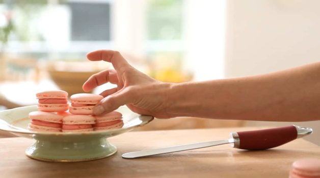 Placing French Macaron on a small green cake stand