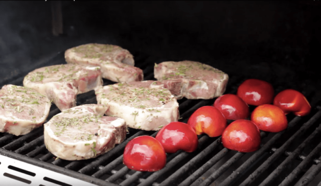 pork chops and nectarines grilling on a BBQ
