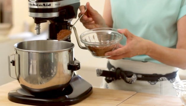  Poudre de cacao mise à la cuillère dans un mélangeur sur pied