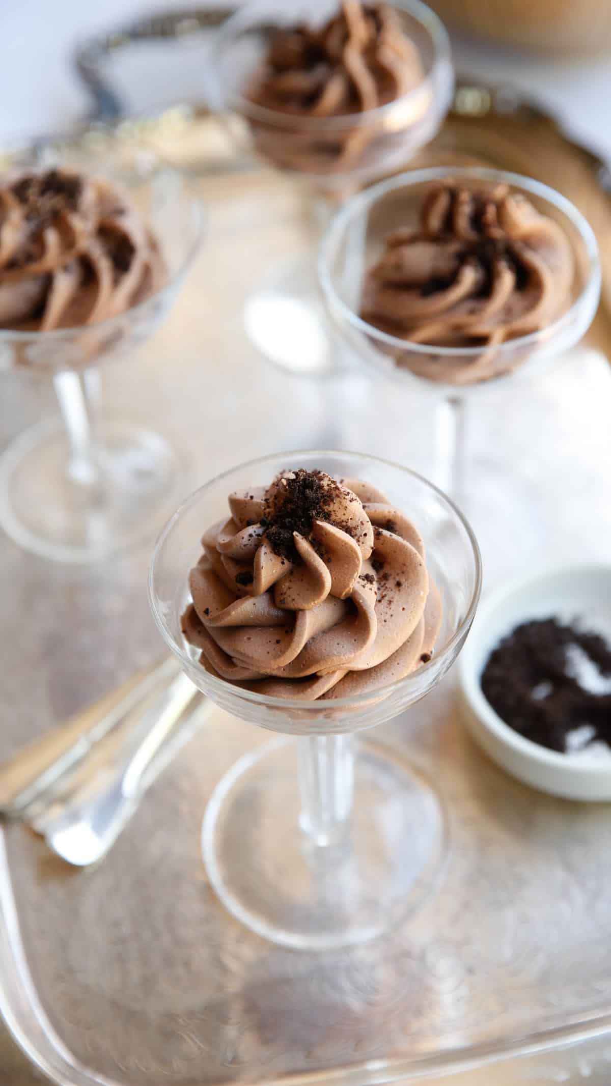 champagne glasses filled with chocolate mousse on a silver tray