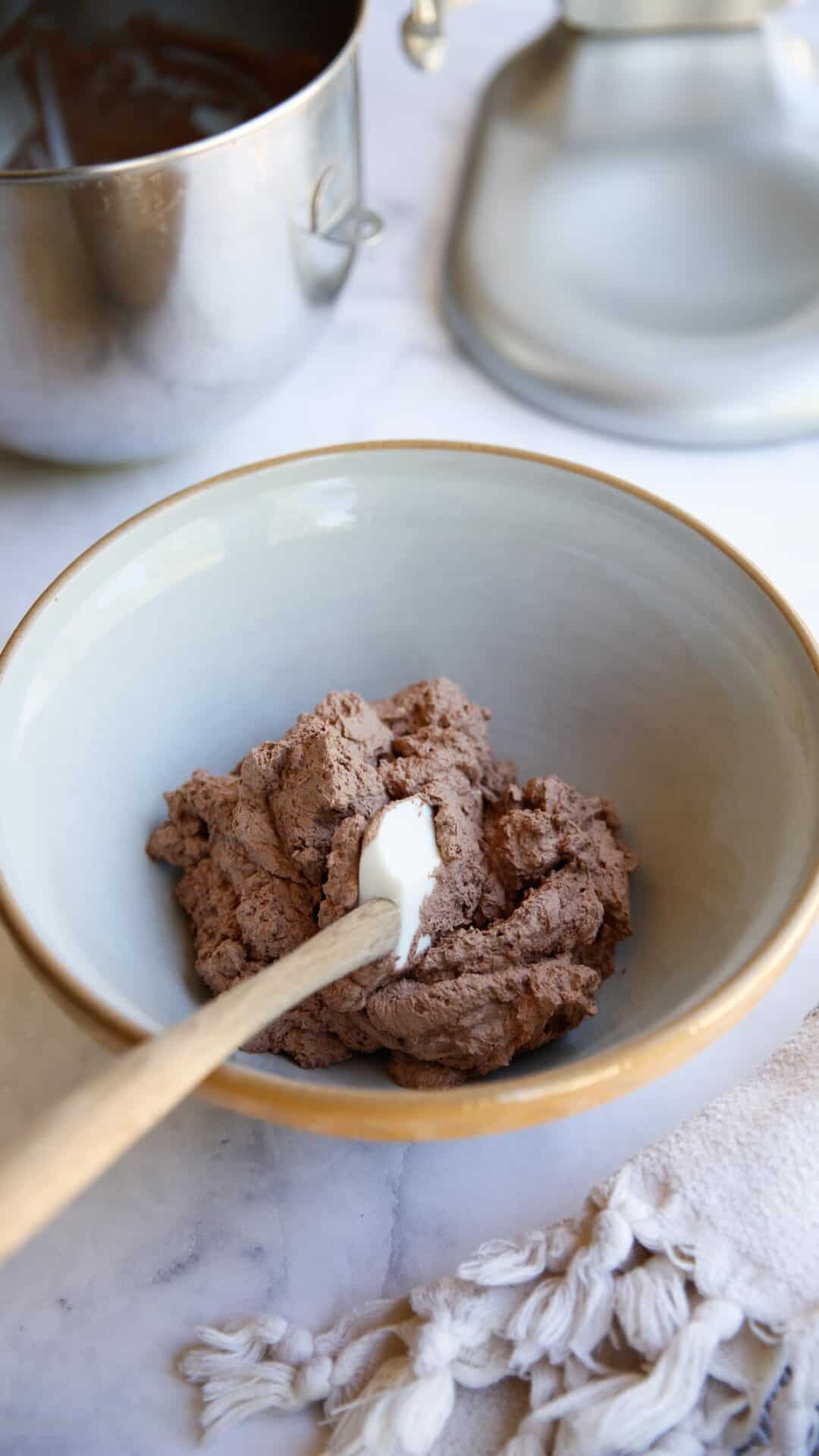 a bowl of whipped chocolate whipped cream with a spatula in it