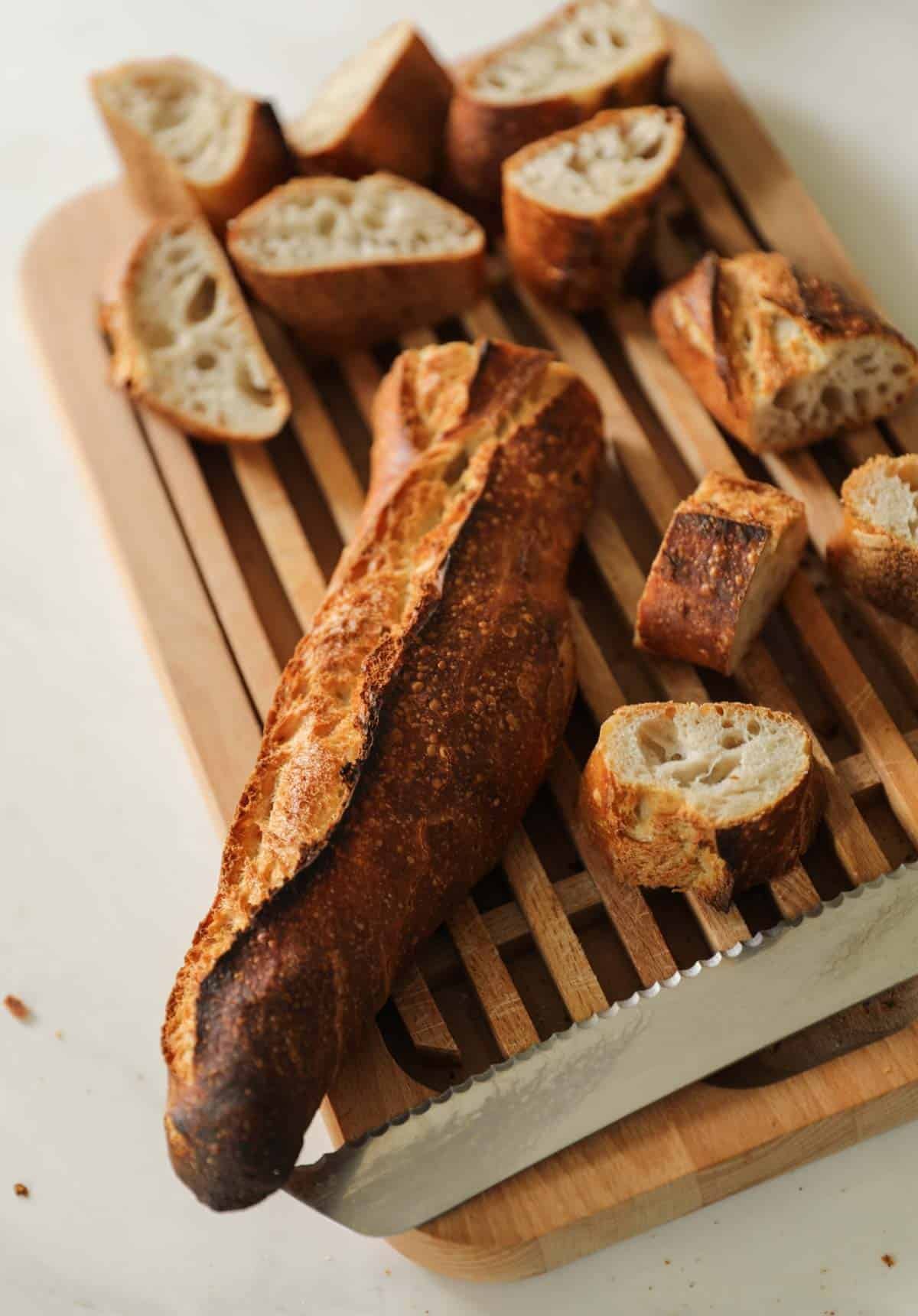 A stale French baguette sliced on a cutting board.