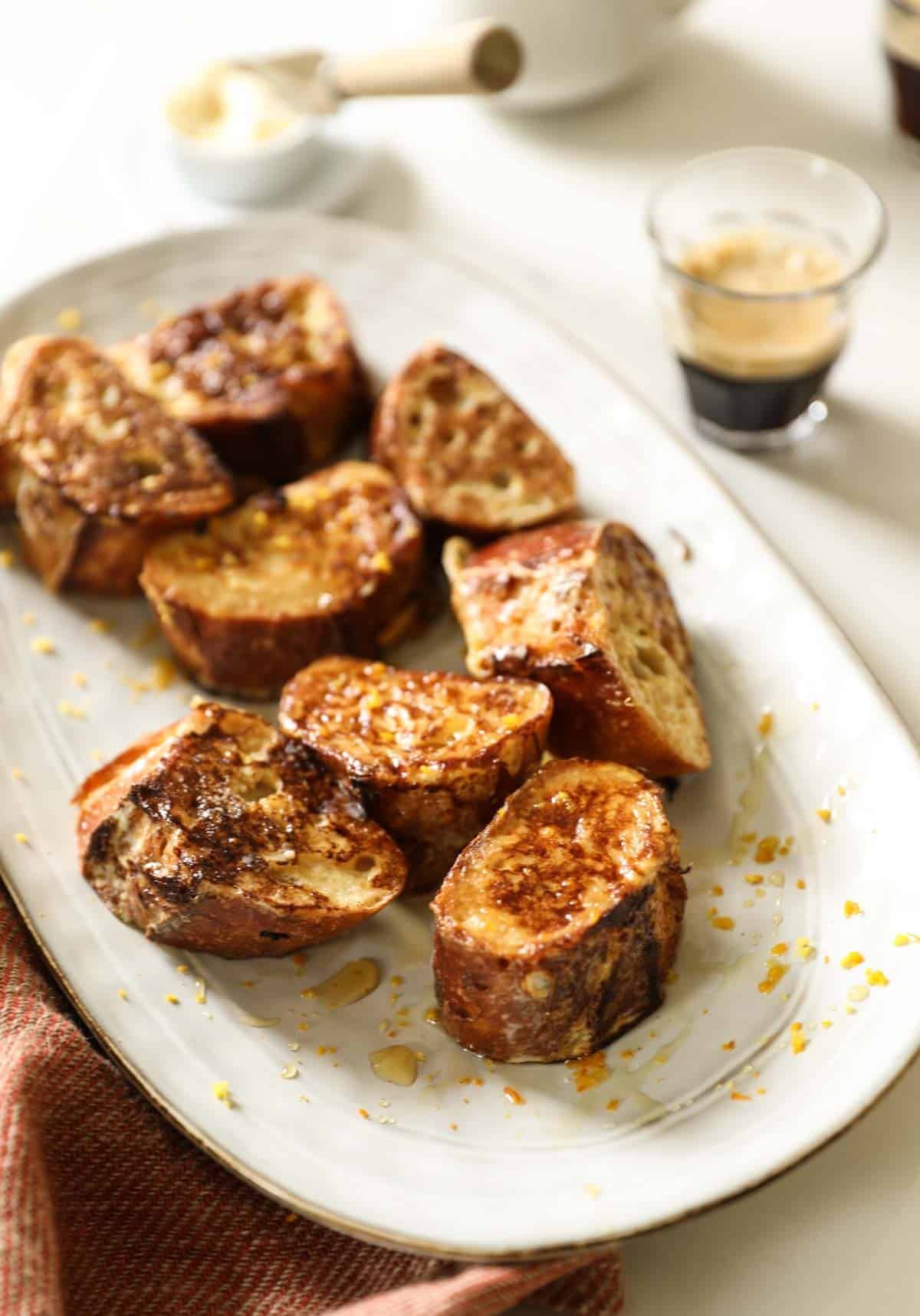 a platter of French toast with coffee in the background.