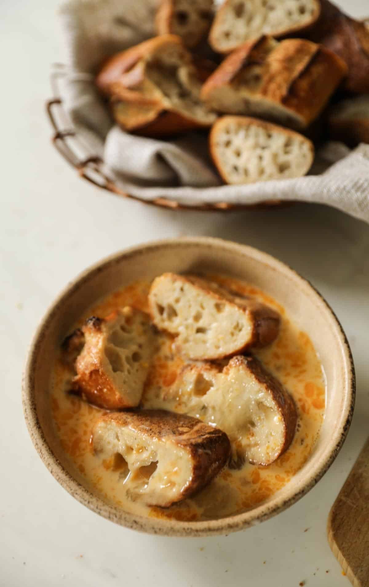 Sliced baguette soaking in egg bath.