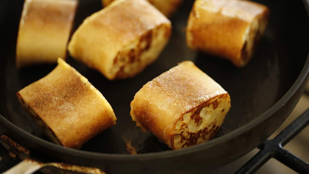 bread slices on sides in skillet being cooked on opposite side