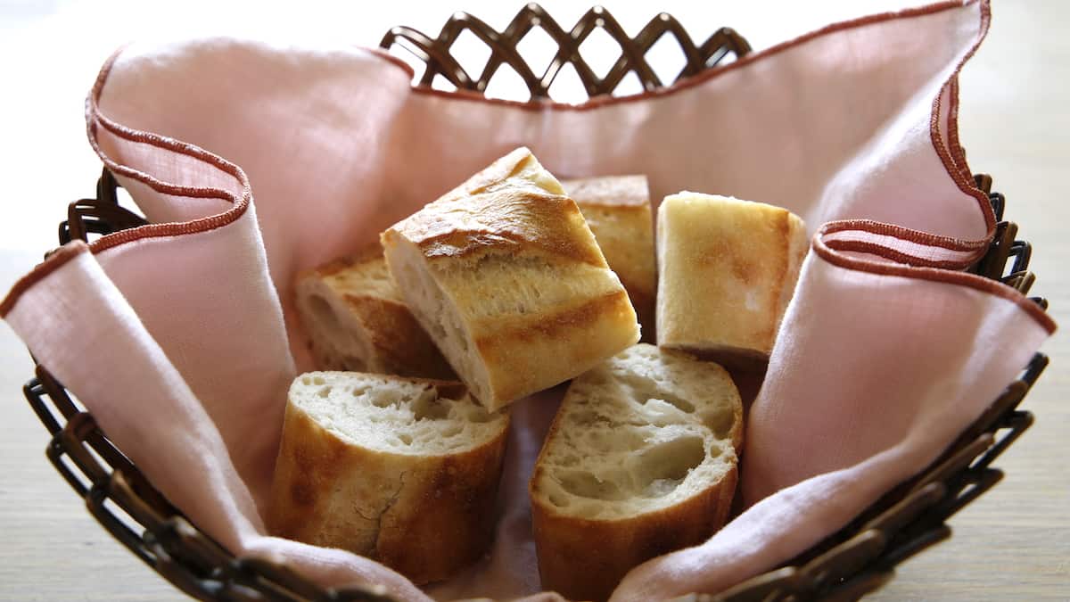 Sliced Baguette Bread in a bread basket with Pink cloth