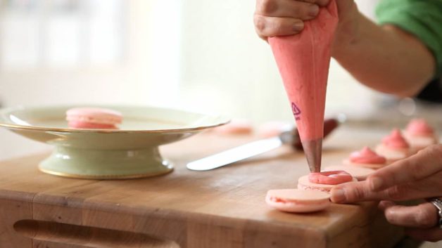 Piping filling in Pink Macaron Shells