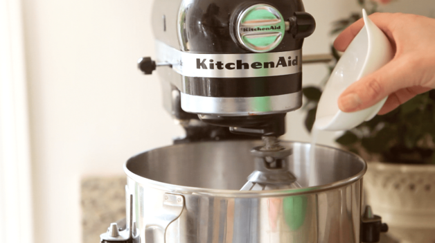 pouring sugar into an electric mixer