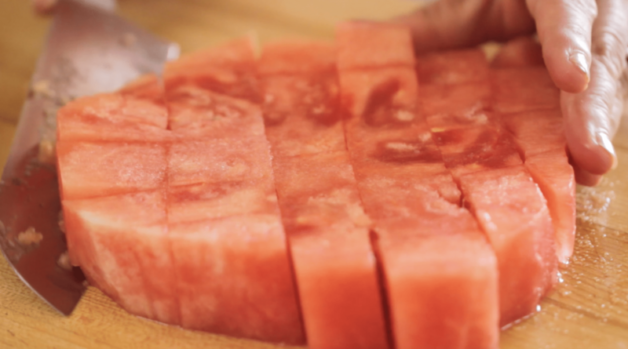 How to Make Watermelon Lemonade the watermelon sliced into chunks on a wood surface