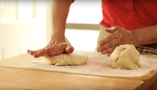 pie dough being rolled out on a wood board 