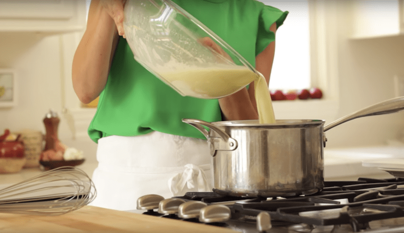 ice cream mixture being added back into a large pot to cook